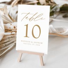 a table number sign sitting on top of a wooden easel