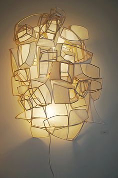 a light that is on top of a white wall next to a lamp with many square shapes