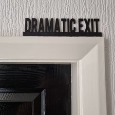 a sign that says dramatic exit on top of a white door frame in front of a white wall