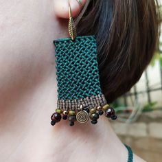 a close up of a person wearing some kind of earring with beads on it