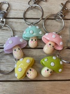 four little mushroom keychains are sitting on a table