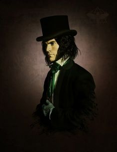 a man with long hair wearing a top hat and green tie, standing in front of a dark background