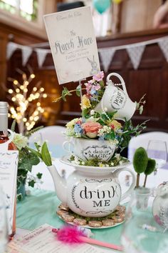 there is a tea pot with flowers in it on top of a table next to other items