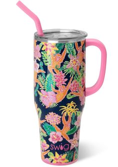 a cup with a straw in it and colorful flowers on the inside, sitting next to a pink handle