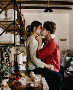 a man and woman kissing in the kitchen