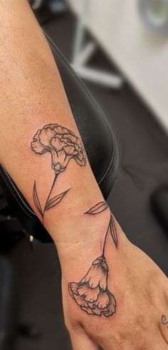 a woman's hand with a flower tattoo on it