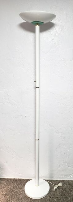 a white floor lamp sitting on top of a carpeted floor