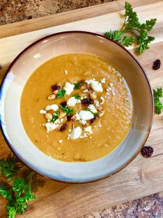 a bowl filled with soup on top of a wooden cutting board