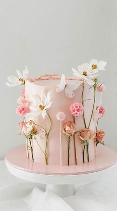 a pink cake with white and pink flowers on top