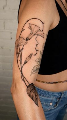 a woman's arm with a flower and leaves tattoo on the left side of her body