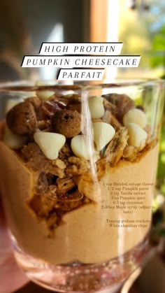 a person holding up a glass with some food in it's middle and the words high protein pumpkin cheesecake parfait on top