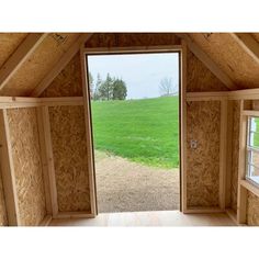 an open window in the side of a building with wood framing and walls that have been boarded down