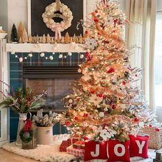 a decorated christmas tree in front of a fireplace