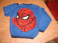 a knitted spiderman sweater sitting on top of a table