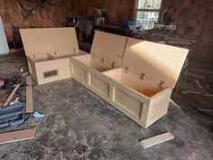 two wooden boxes sitting on top of a floor in a room with unfinished wood walls