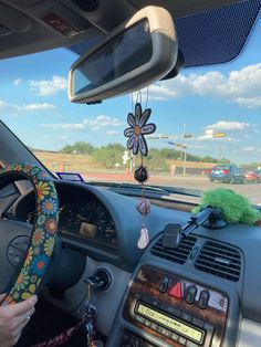 a car dashboard with a steering wheel hanging from it's center console, and a flower decoration on the dash