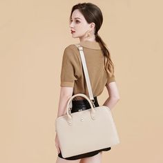 a woman is holding a white handbag