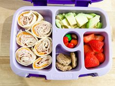 a purple lunch box filled with fruit and veggies