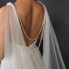 the back of a woman's wedding dress with pearls on it