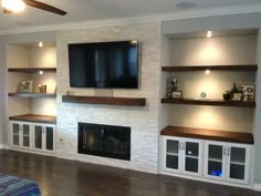 a living room with built in shelves and a flat screen tv mounted on the wall