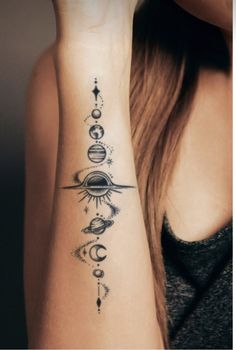 a woman's arm with tattoos on it and an image of the sun, moon, planets