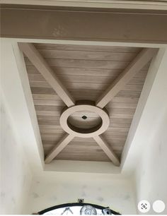 the ceiling in this room has a circular light fixture on it and is made out of wood