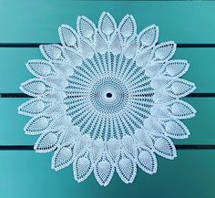 a white doily sitting on top of a wooden table next to a blue wall