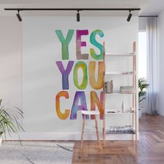 the words yes you can are painted on a wall in a room with wooden floors