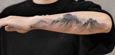 a man with a mountain tattoo on his arm