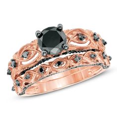 a black diamond engagement ring set on top of an intricate rose gold wedding band,