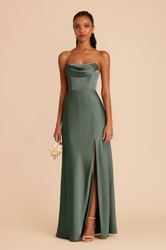 a woman in a green strapless dress with high slit and side slit, holding a bouquet