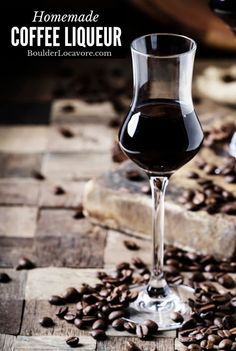 a glass filled with liquid sitting on top of coffee beans