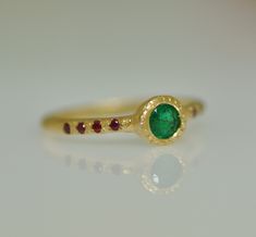 18k solid gold ring. Indian style Emerald and Ruby ring. Green round 5 m"m Emerald sets in a unique setting in the center of a round gold bezel. The bezel is a little higher than the ring. Small Ruby stones set on the two sides of the bezel, 4 stones from each side of the Emerald. This ring was handmade engraved by me and casted in one part to 18k gold. This is defiantly a unique gift for a woman. 14k rose gold ring for women. The ring looks Indian ring, the colors, style, and a handmade look. Indian Ring, Ring Indian, Indian Rings, Handmade Gold Ring, Green Emerald Ring, Gold Gemstone Ring, Solid Gold Ring, 14k Rose Gold Ring, Ruby Stone