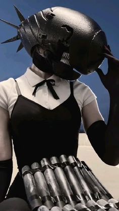 a woman in black and white dress holding a helmet on her head