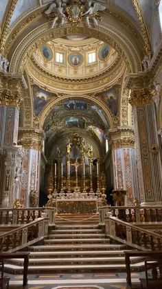 the inside of a church with gold and white decorations on the walls, pews and stairs