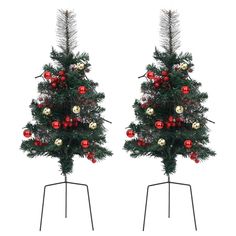 two christmas trees with ornaments on them are standing next to each other in front of a white background