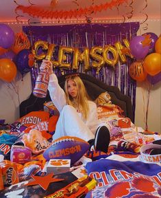 a woman sitting on top of a bed surrounded by balloons