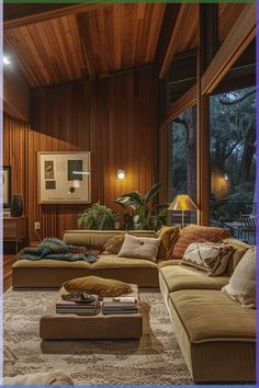 a living room filled with lots of furniture next to a large window covered in wood paneling