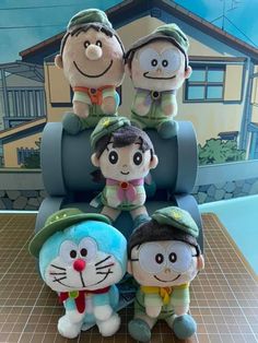 several stuffed animals sitting on top of a chair in front of a wall with cartoon characters