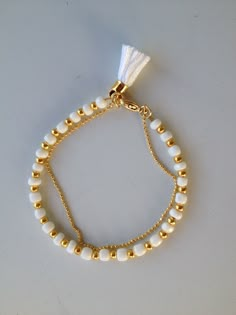 two bracelets with white and gold beads