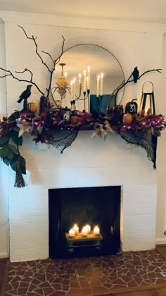 a fireplace decorated with candles and branches