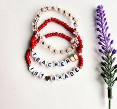 three beaded bracelets with the words teacher, first grade and second grade written on them