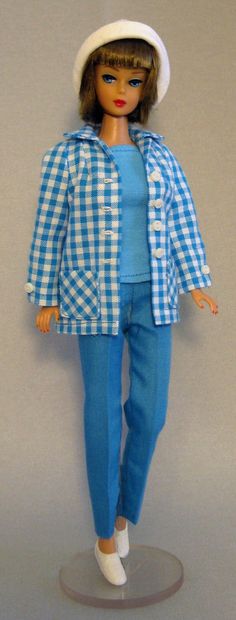 a doll is dressed in blue and white checkered clothes with a hat on her head