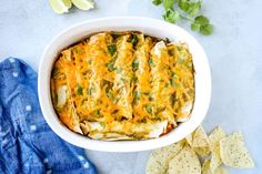 a casserole dish with tortilla shells, cheese and cilantro