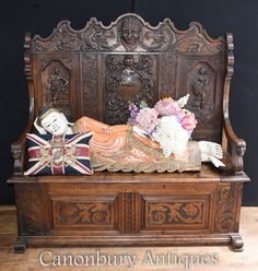 an old wooden bench with flowers and other decorations on it's back end,