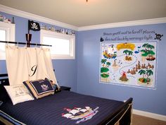 a child's bedroom decorated in blue and white with a pirate map on the wall