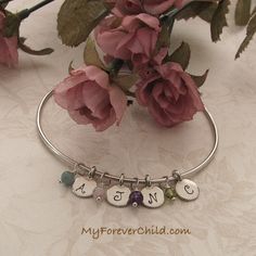 This bangle bracelet features one mini round charm hand stamped with one initial to add a touch of personalization. Also adorned with a genuine gemstone dangle. This is a perfect way to represent each of your children, family members, or loved ones.  | My Forever Child #myforeverchild Infant Loss, Bangle Bracelets With Charms, Memorial Jewelry