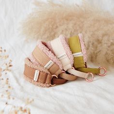 four pairs of pink, beige and green hair ties on top of a white blanket