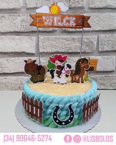 a birthday cake decorated with farm animals and cowboy's name on the top tier