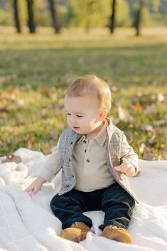 a little boy sitting on top of a blanket